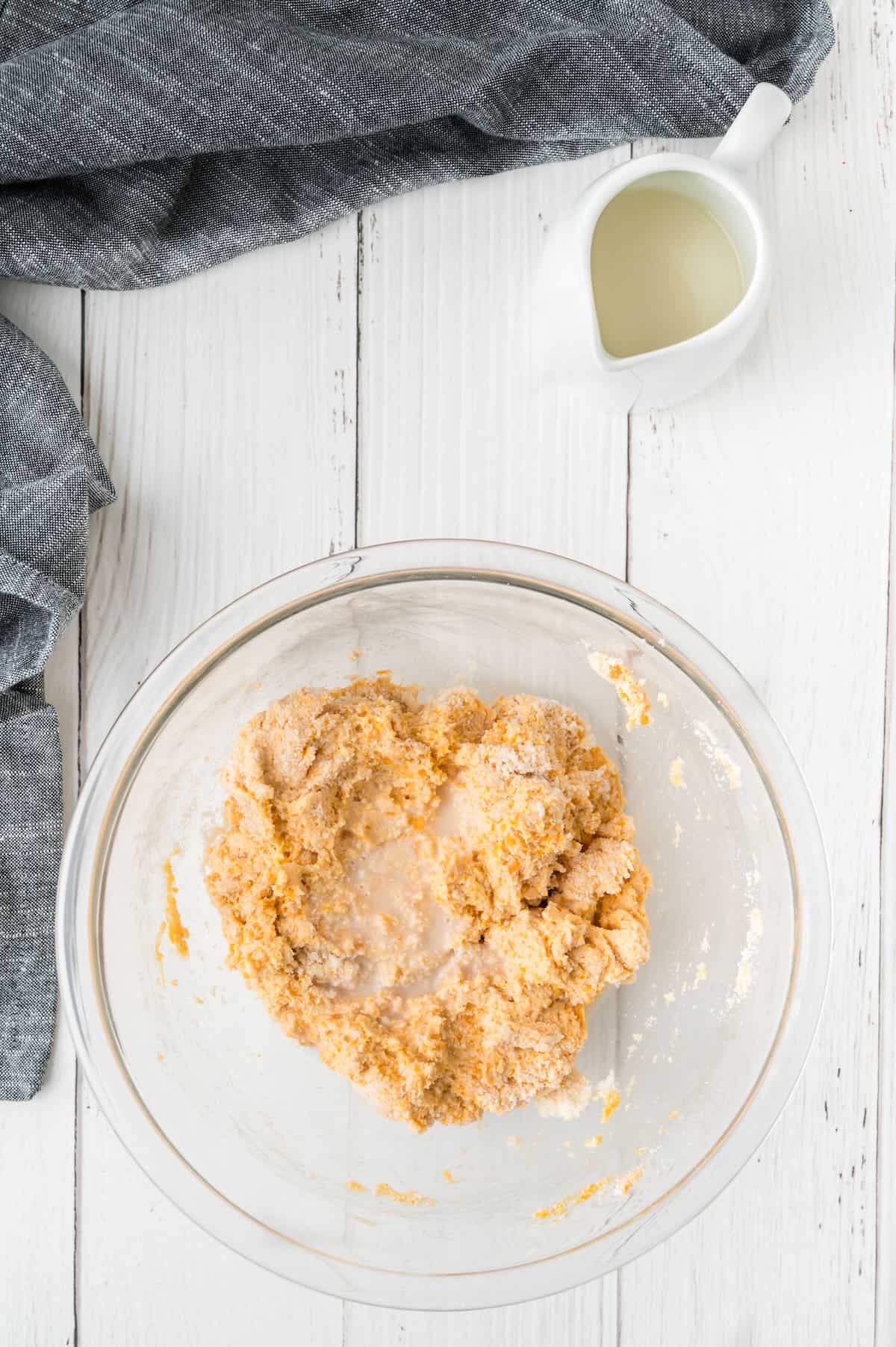 Biscuit dough in a clear glass bowl. 