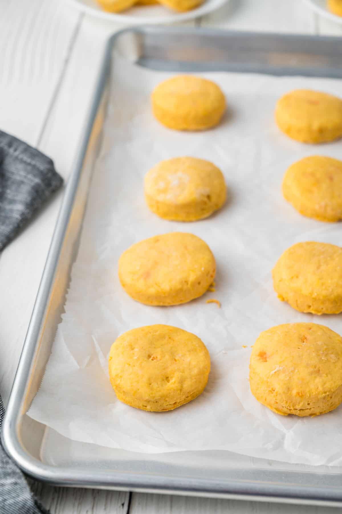 Baked sweet potato biscuits cooling on a baking sheet. 