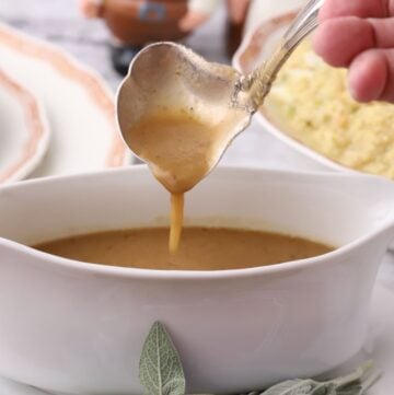 A gravy boat full of Turkey Neck Gravy with a gravy ladle.