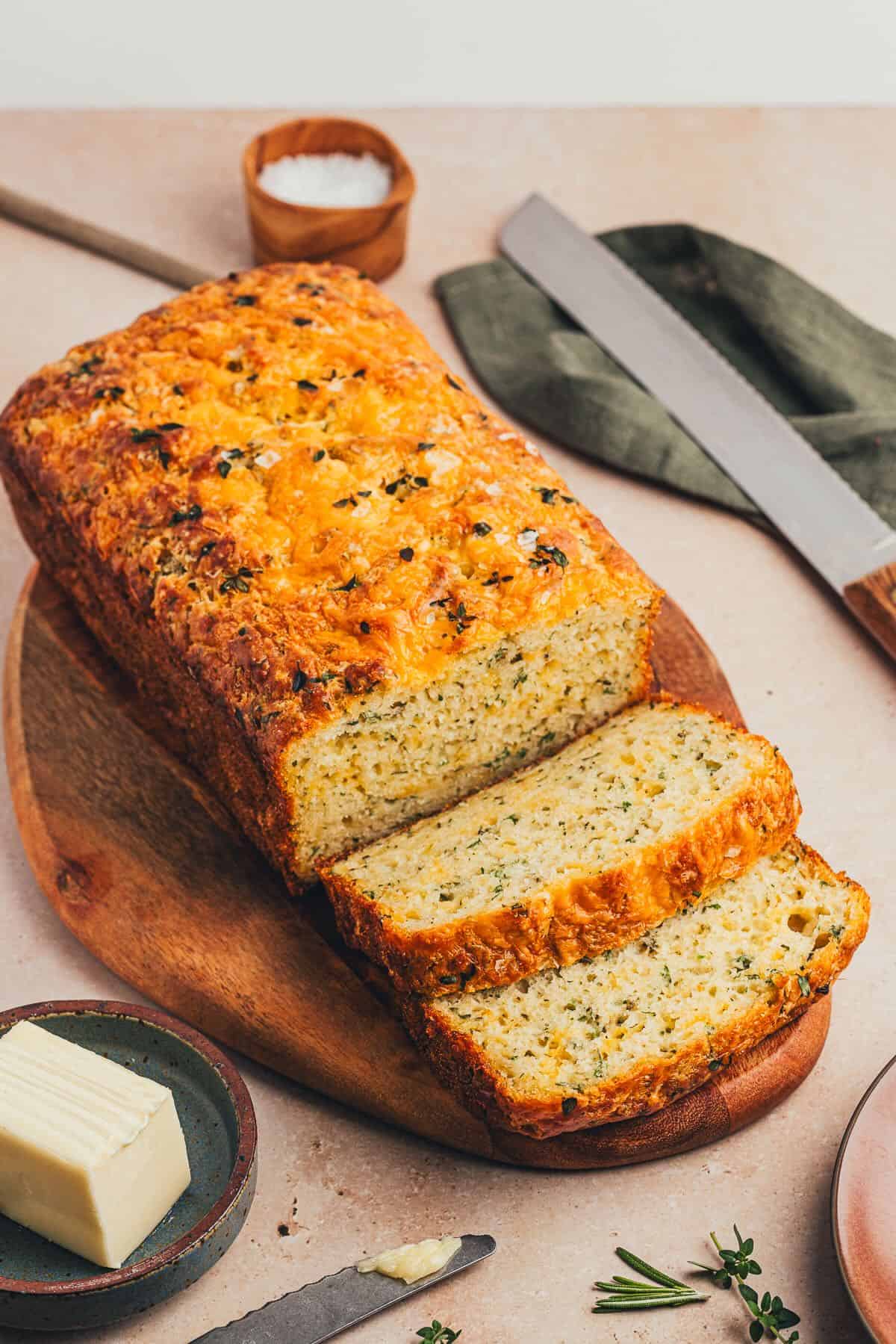 Herb and Cheese Bread on a cutting board with two slices cut. 