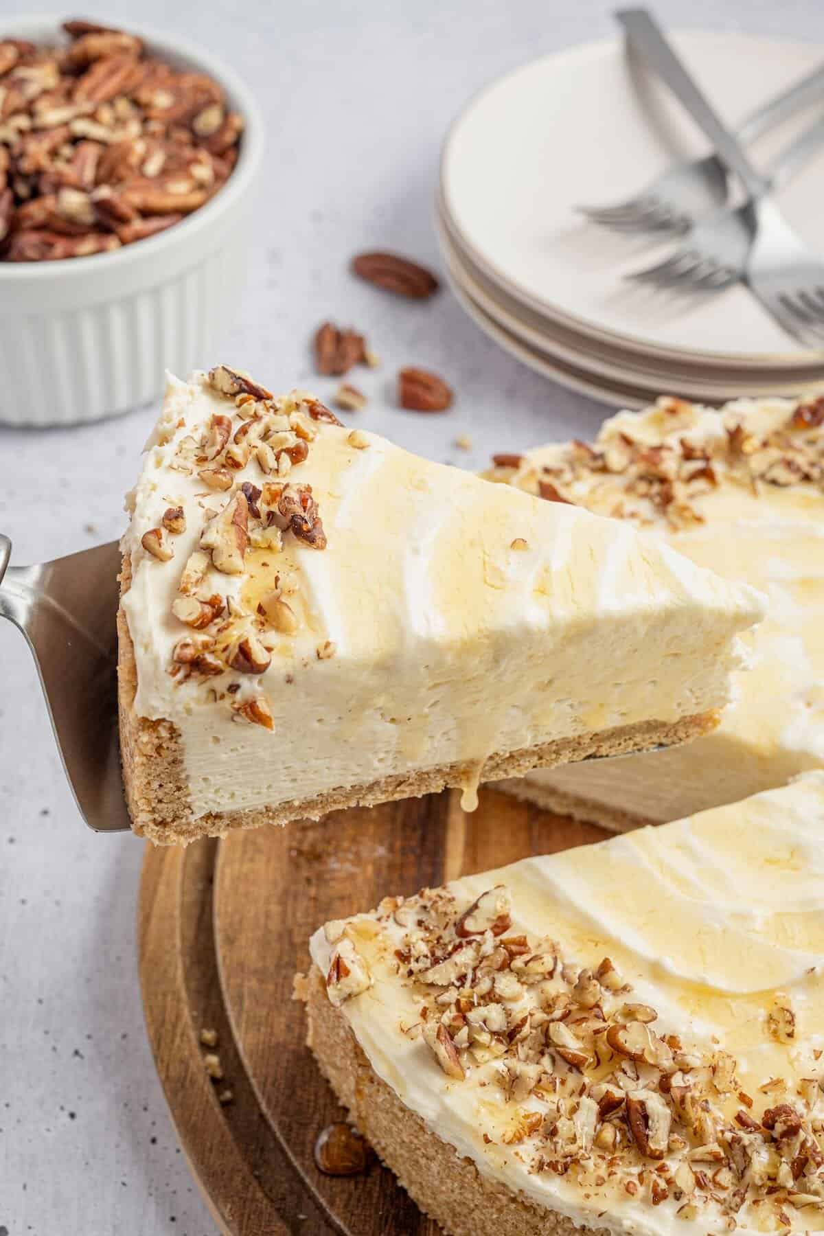 A slice of honey cheesecake topped with pecans and a drizzle of honey.