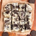Oreo fudge cut into squares on a piece of parchment paper.