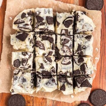 Oreo fudge cut into squares on a piece of parchment paper.