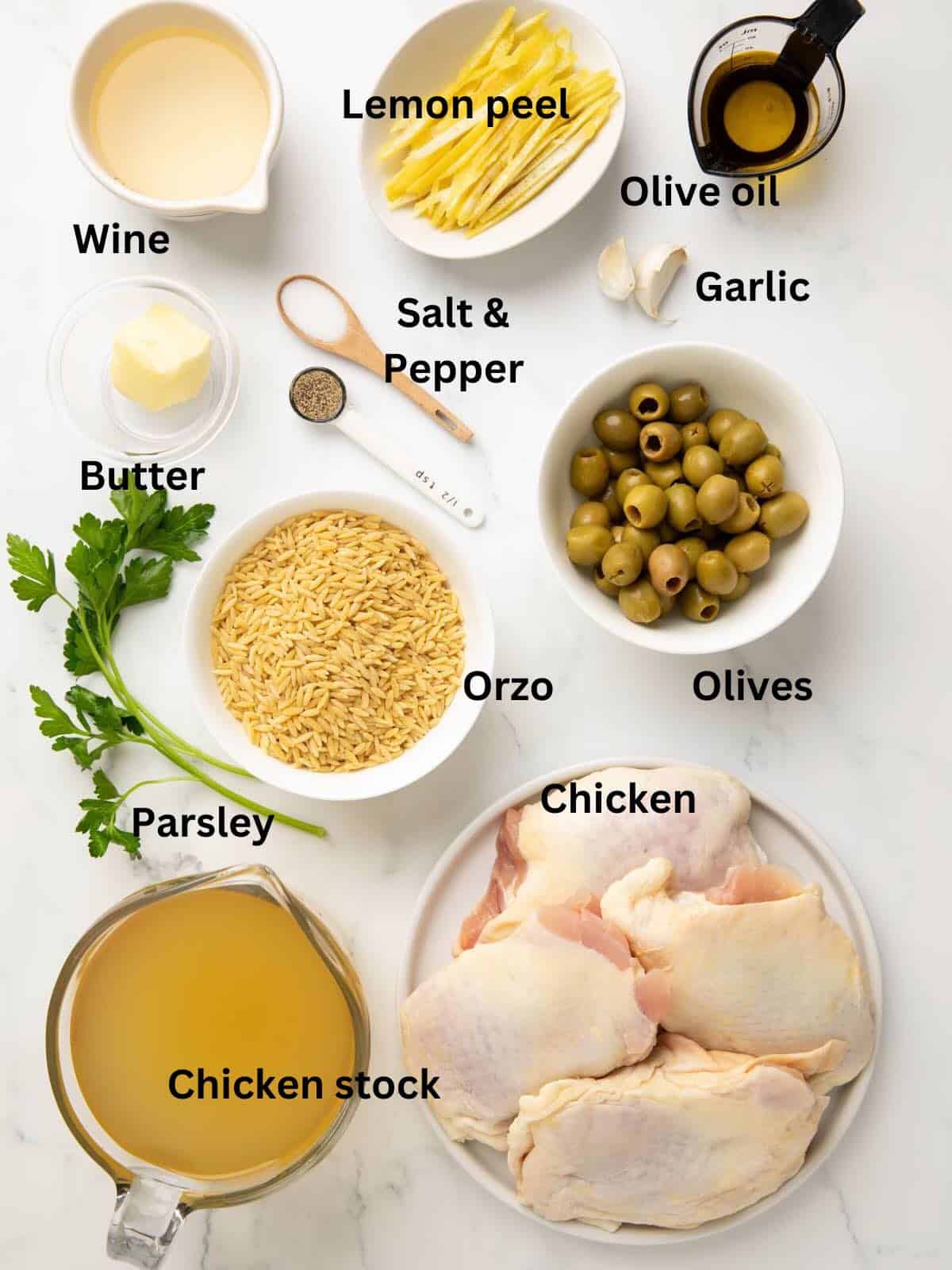 Ingredients in bowls for chicken and orzo bake including chicken, orzo, lemon peels, chicken stock, and wine. 