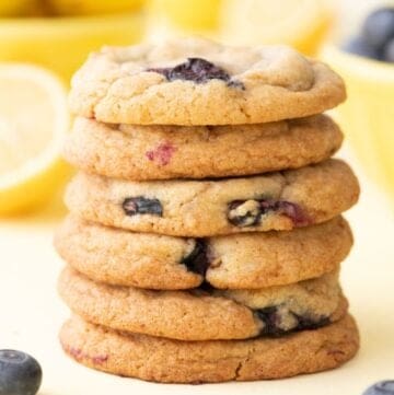 A stack of six lemon blueberry cookies on a plate.