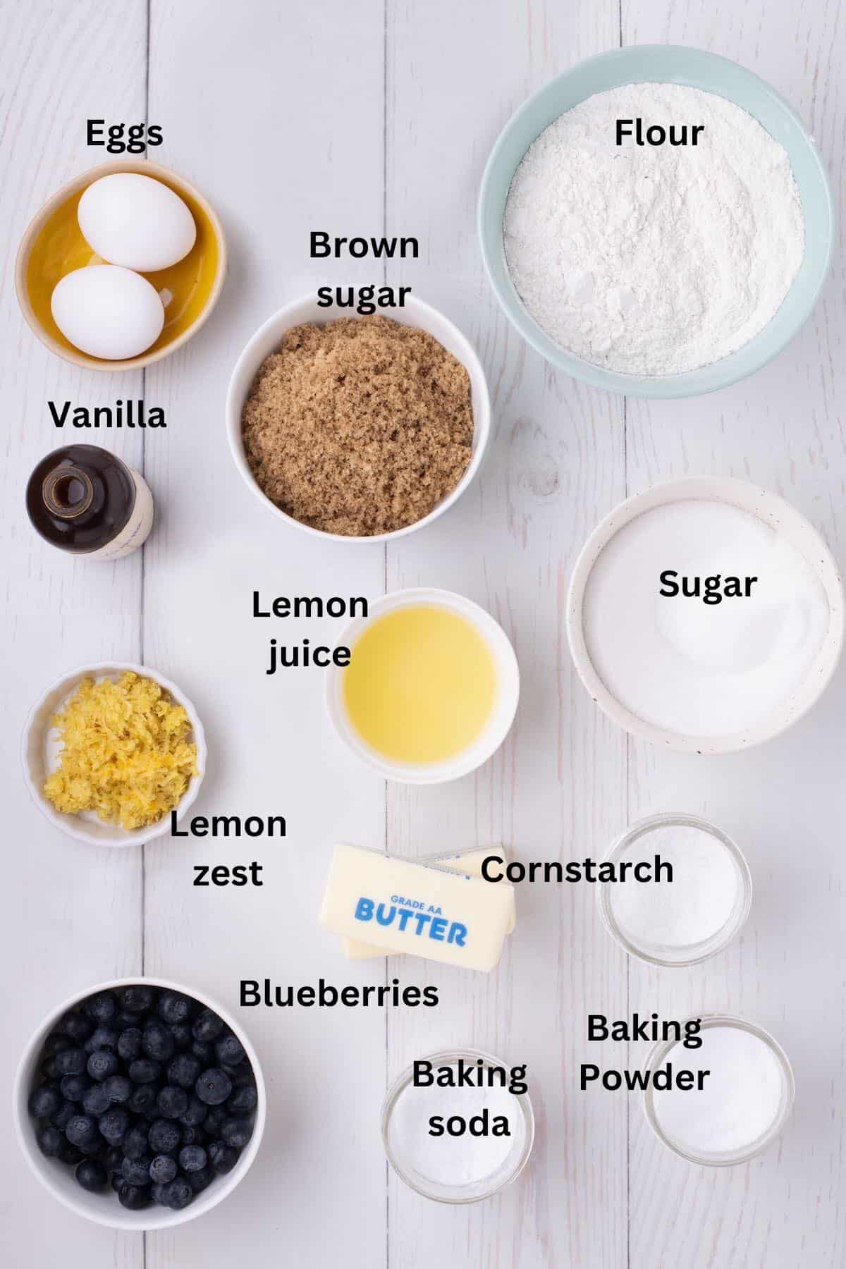 Ingredients in bowls for lemon blueberry cookies including flour, sugar, butter, and blueberries. 