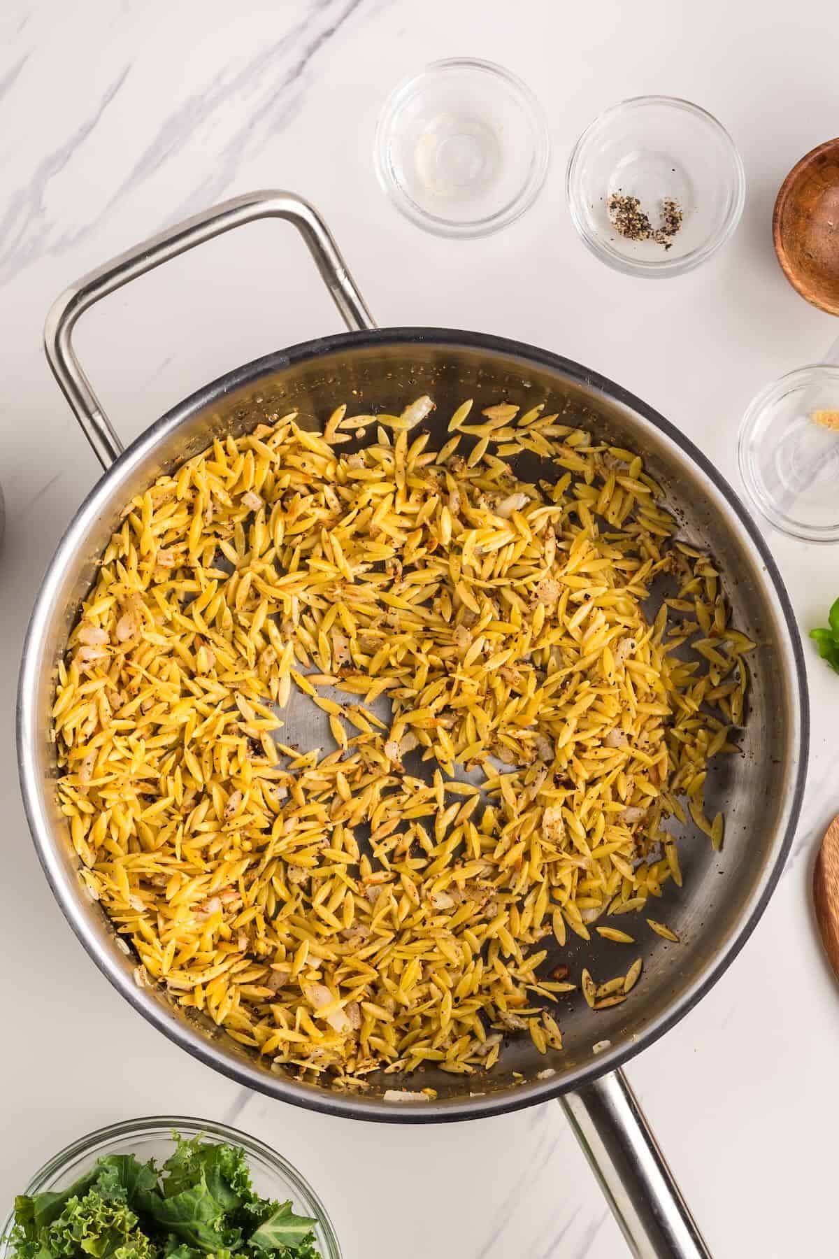 Toasting orzo in in butter and oil in a skillet with onions and garlic