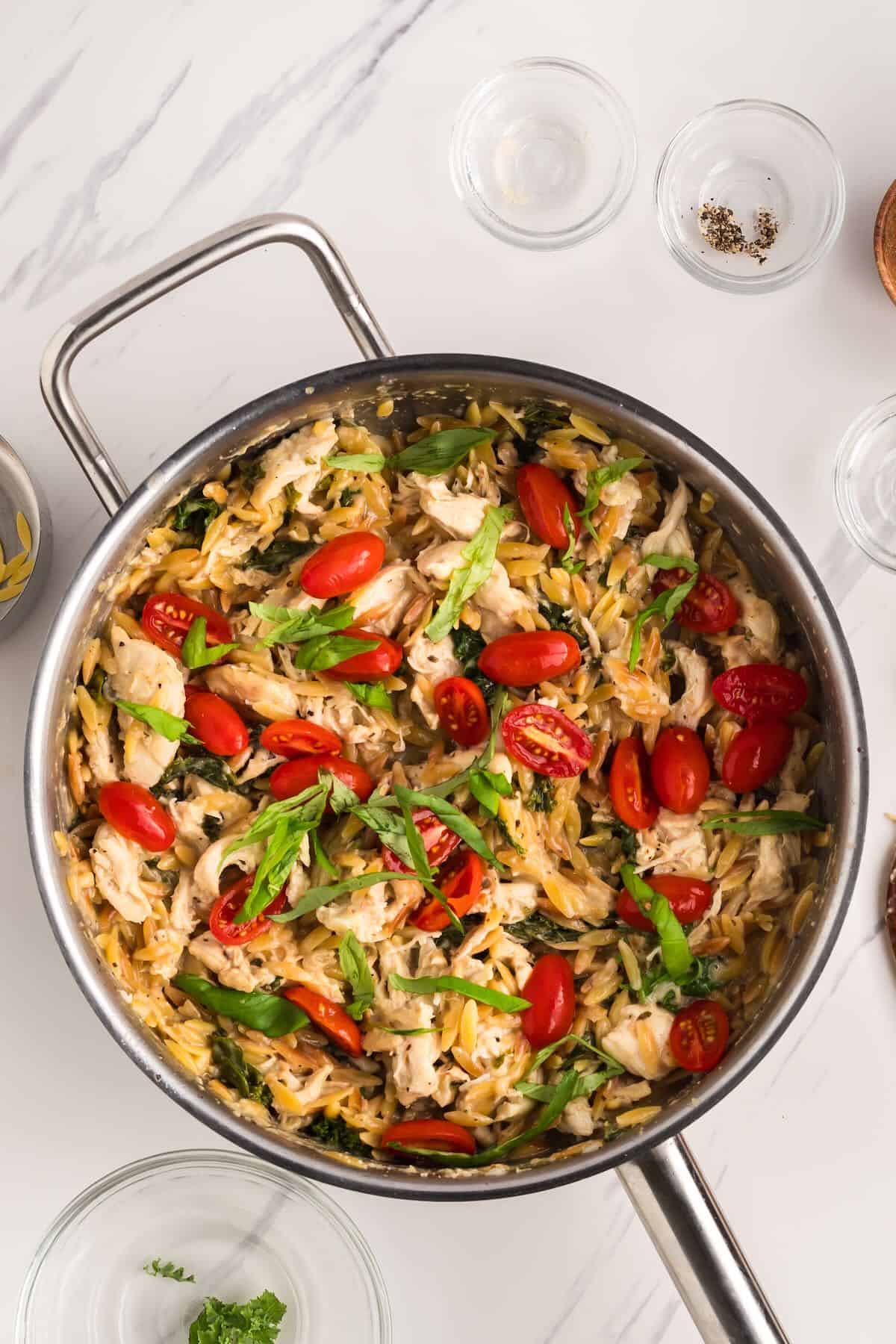 Chicken, cherry tomatoes, and parmesan cheese are added to the orzo mixture.