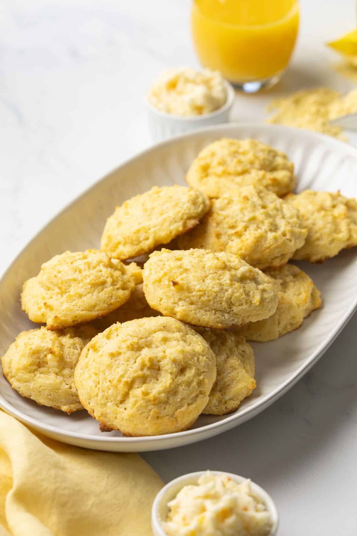 A white platter full of drop cornmeal biscuits. 