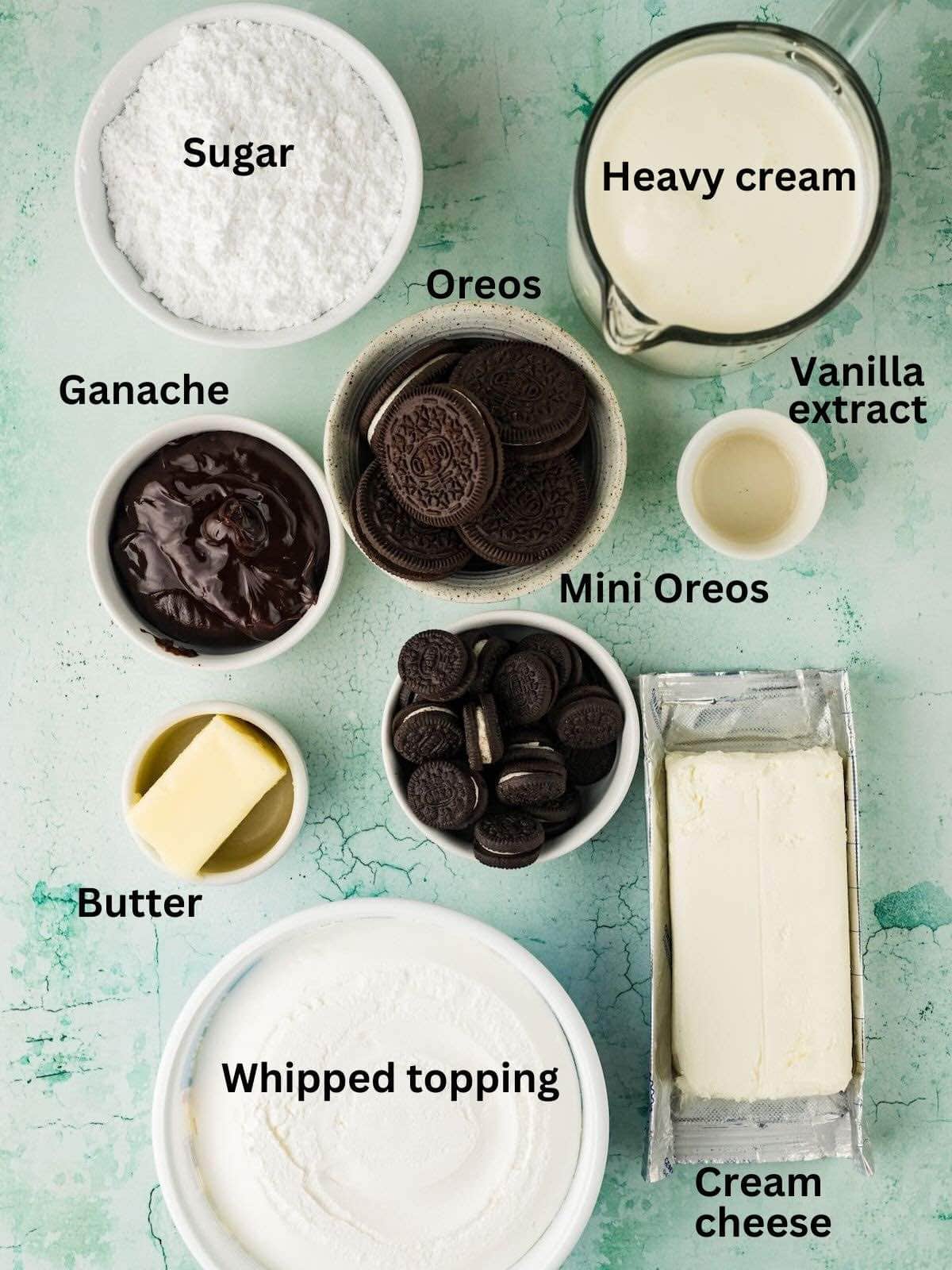 Ingredients to make mini Oreo cheesecakes includes Oreos, whipped topping, heavy cream, ganache, and cream cheese.