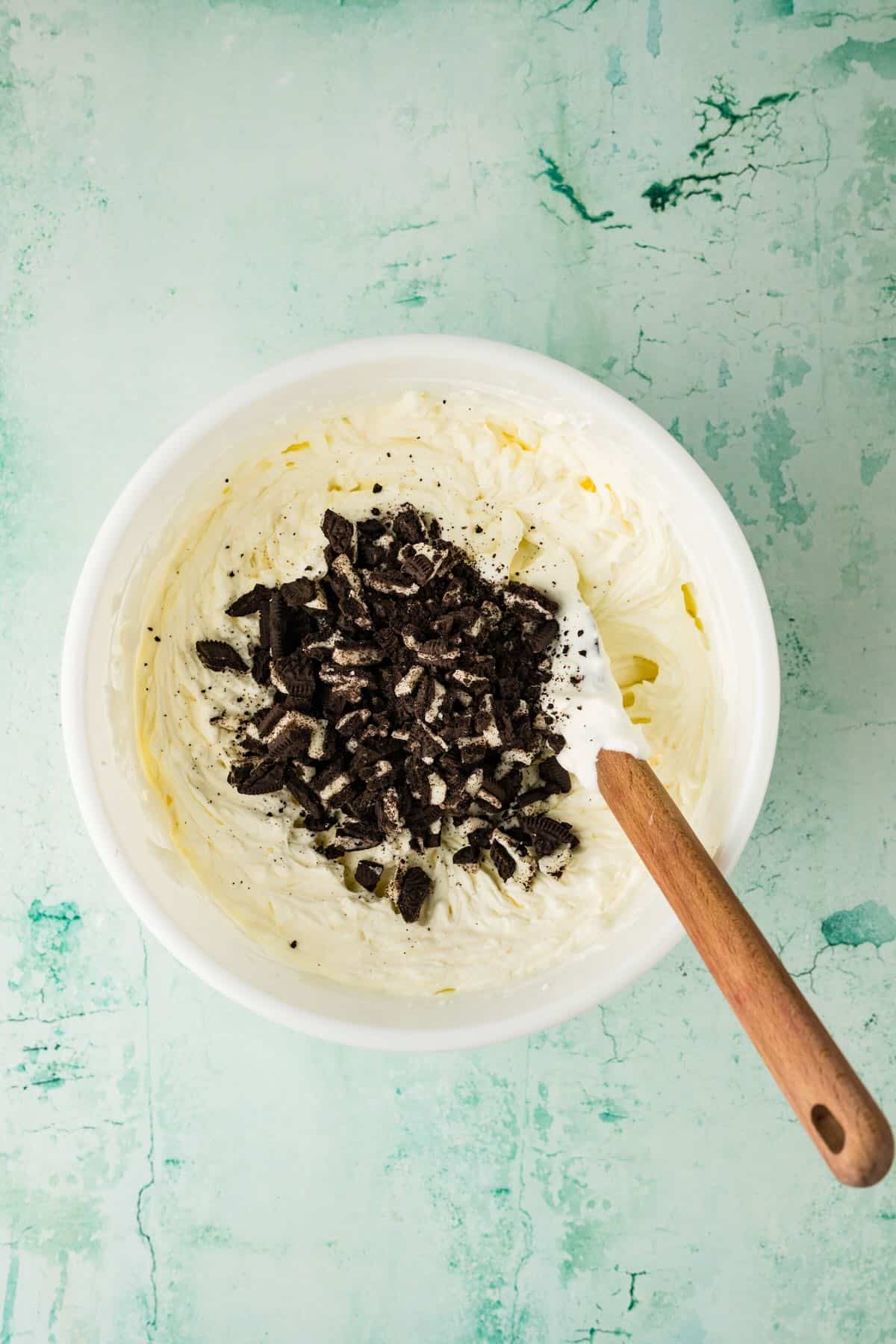 Folding crushed Oreos in to a whipped cream and cream cheese mixture.