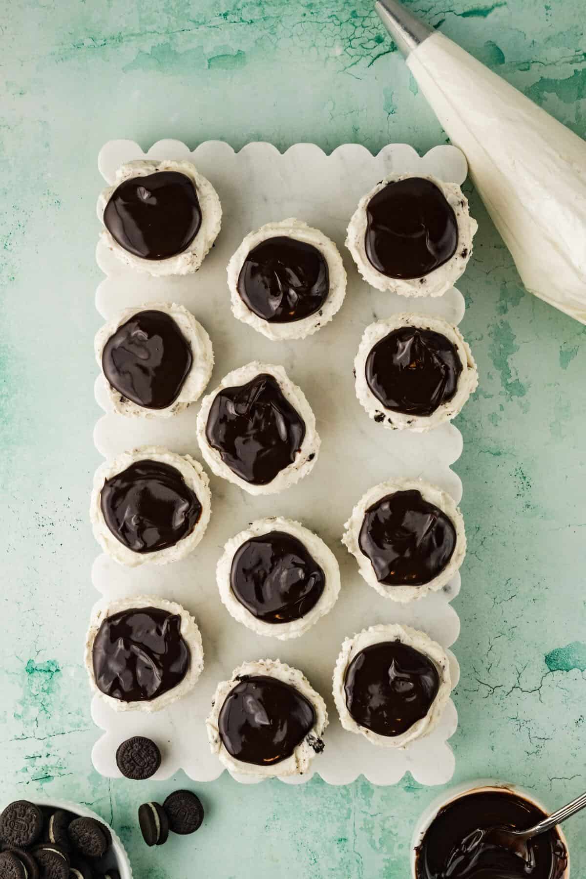Mini Oreo cheesecakes topped with chocolate ganache.