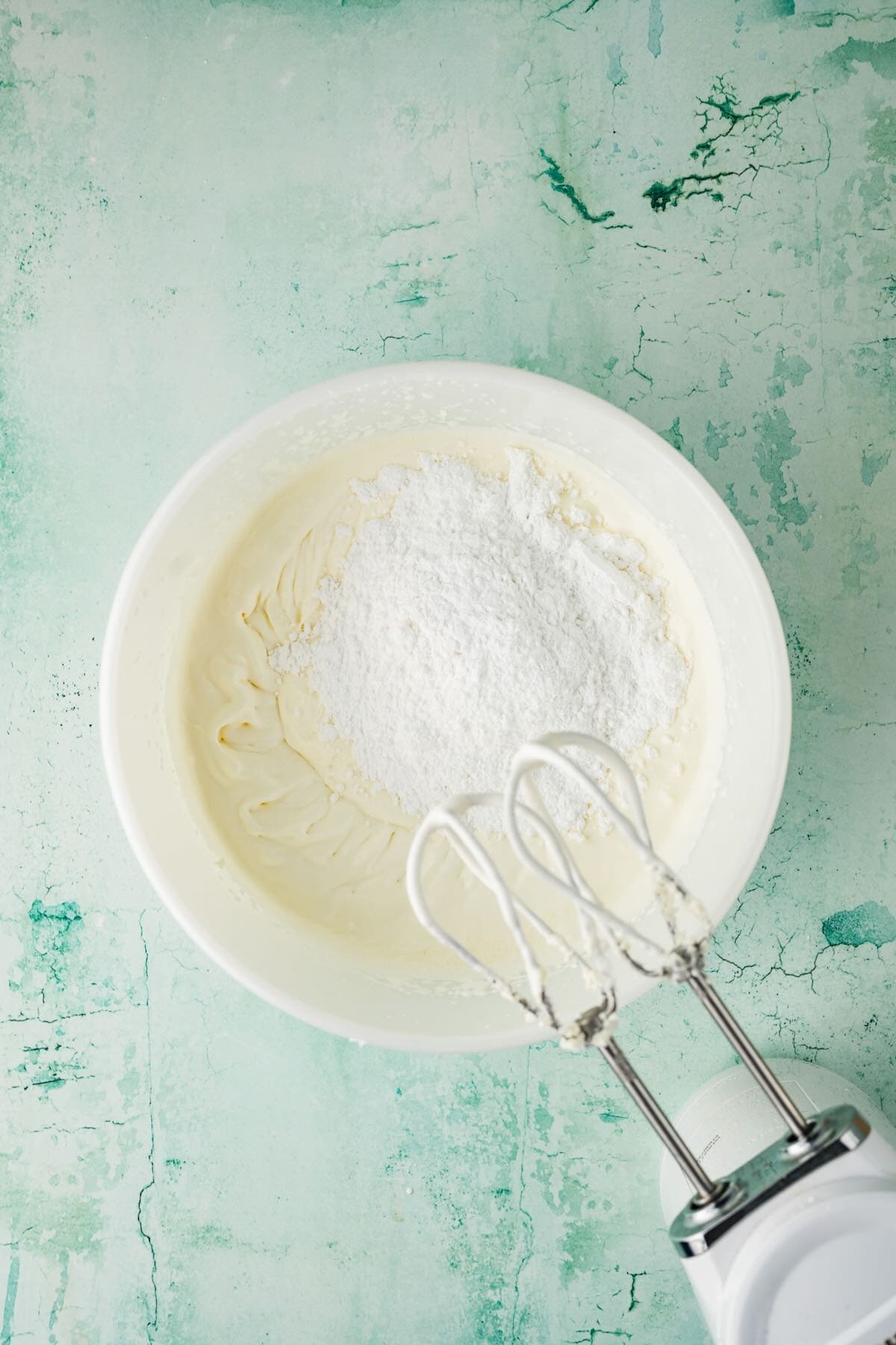 hipped cream in a bowl with powdered sugar added.