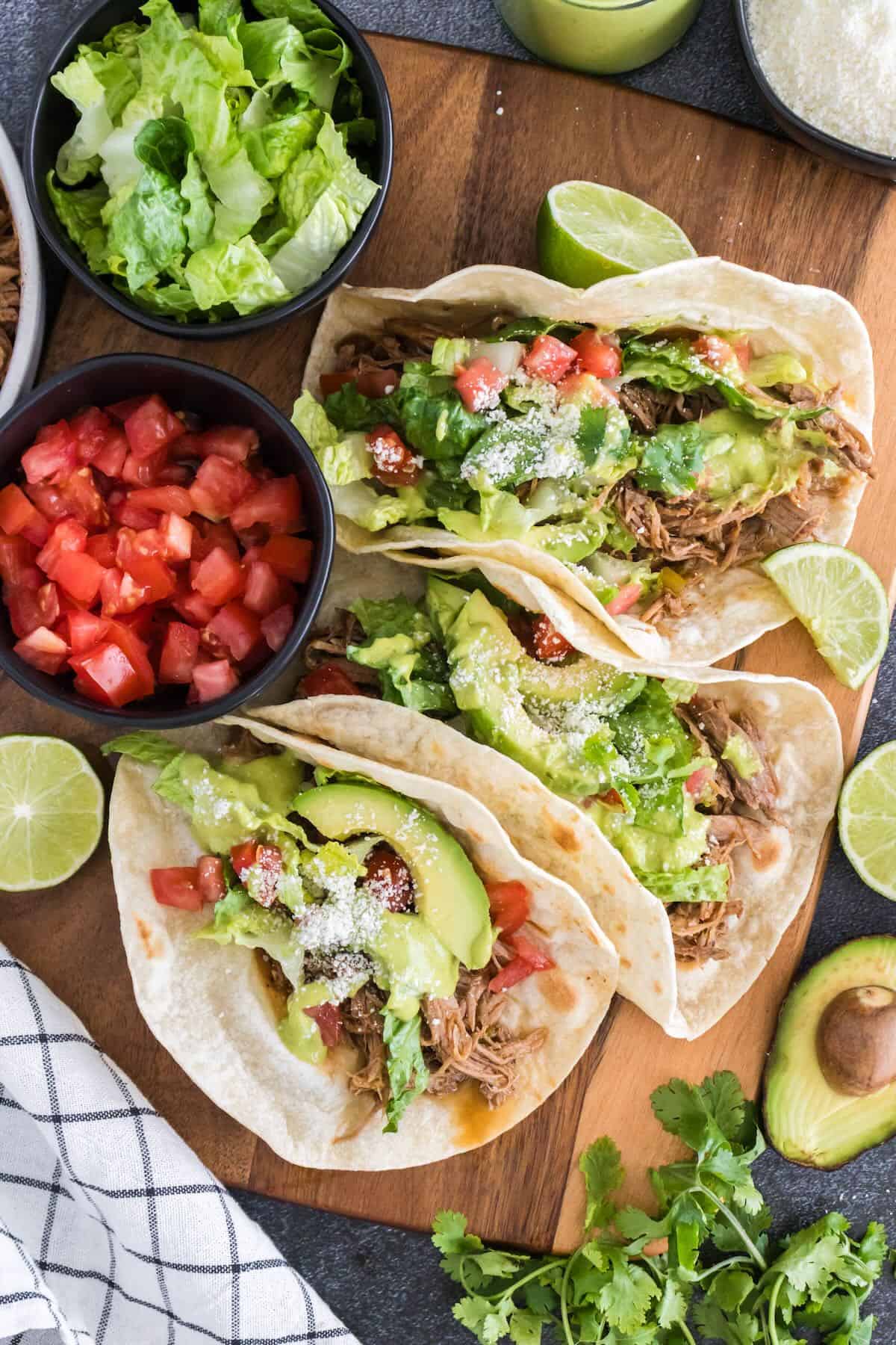 Pulled pork tacos with pork, lettuce, tomatoes, and avocado, cilantro, lime dressing.