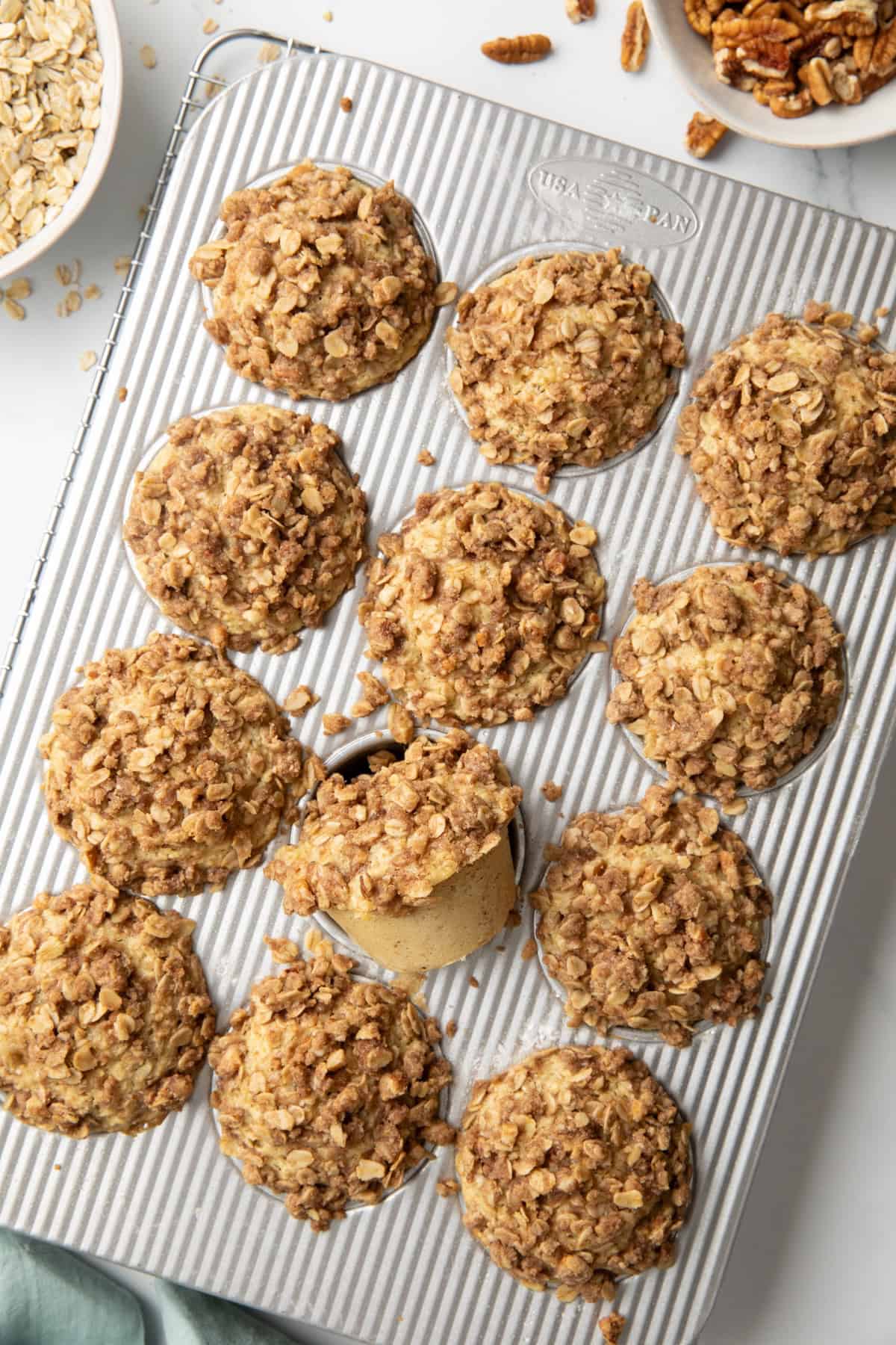 Baked cinnamon oatmeal muffins in a muffin pan. 