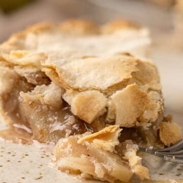 A slice of old-fashioned pear pie on a plate with a fork.