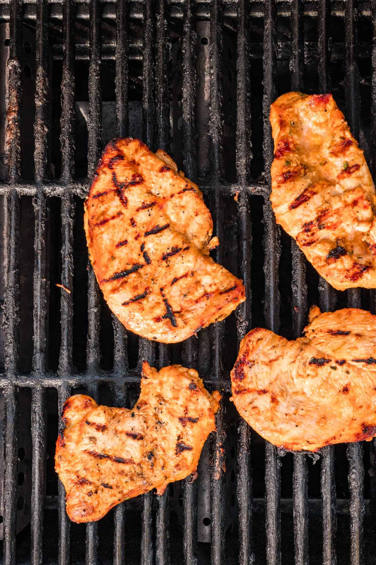 Grilled coconut lime chicken breasts on a grill with grill marks. 