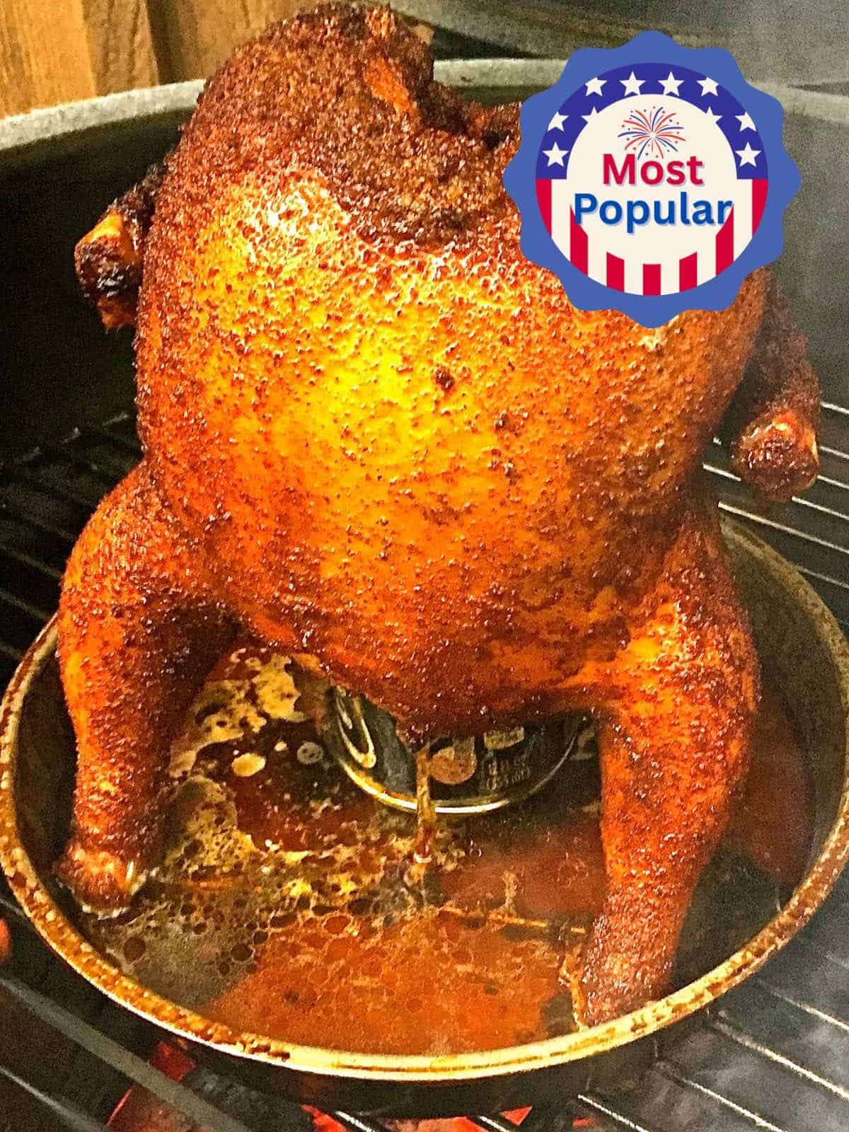 A whole chicken cooking on a grill, sitting on a beer can.