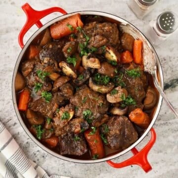 Braised chuck roast with carrots and mushrooms cooked in a red wine sauce.