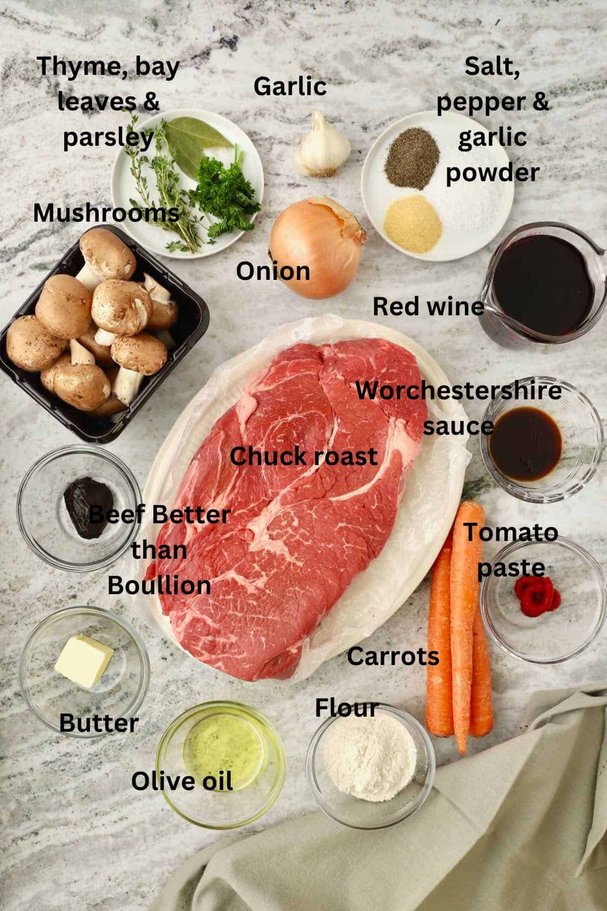 Braised chuck roast ingredients include mushrooms, beef broth, thyme, carrots, seasonings, and onions. 
