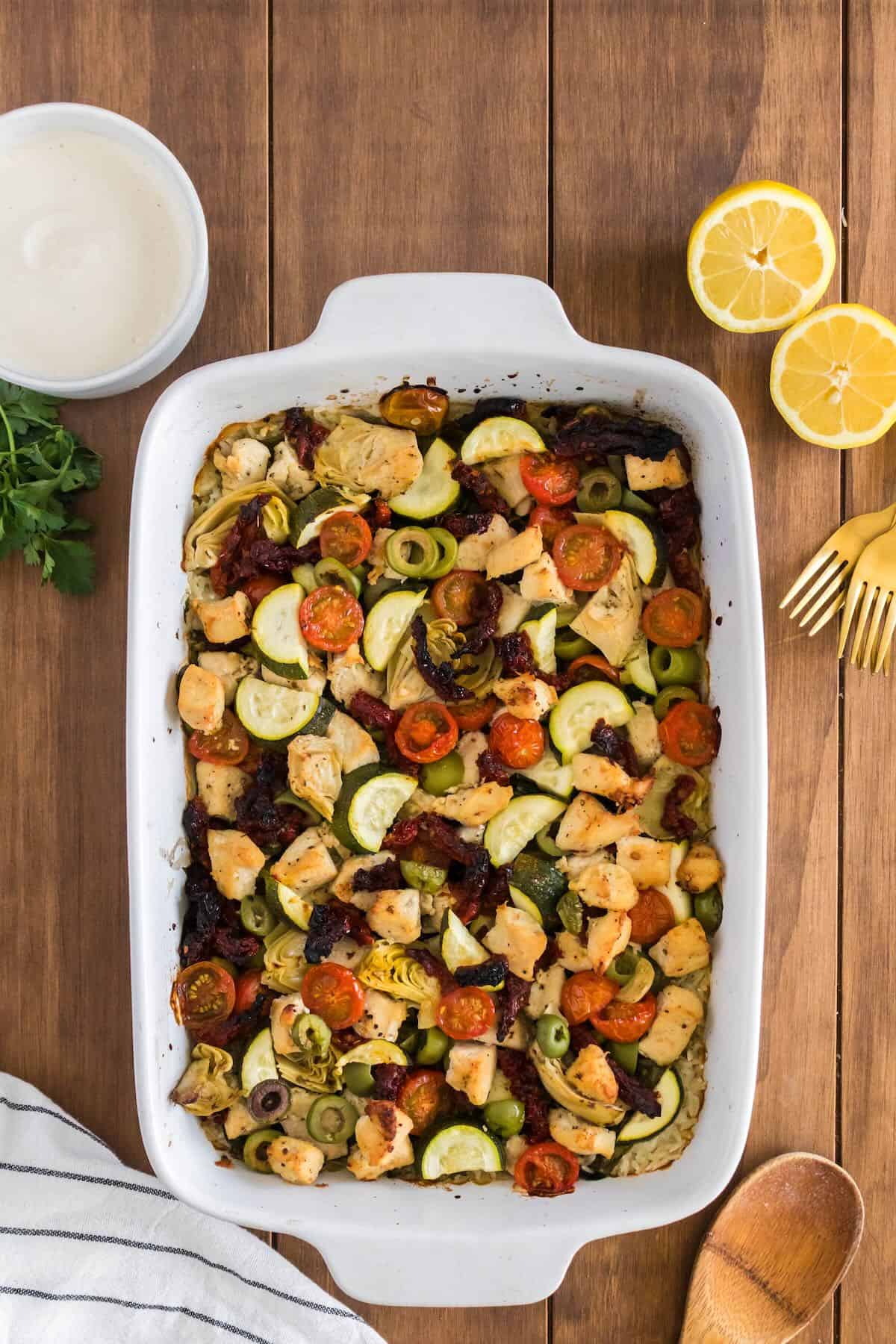 Mediterranean Rice Casserole with Chicken baked in a white baking dish. 