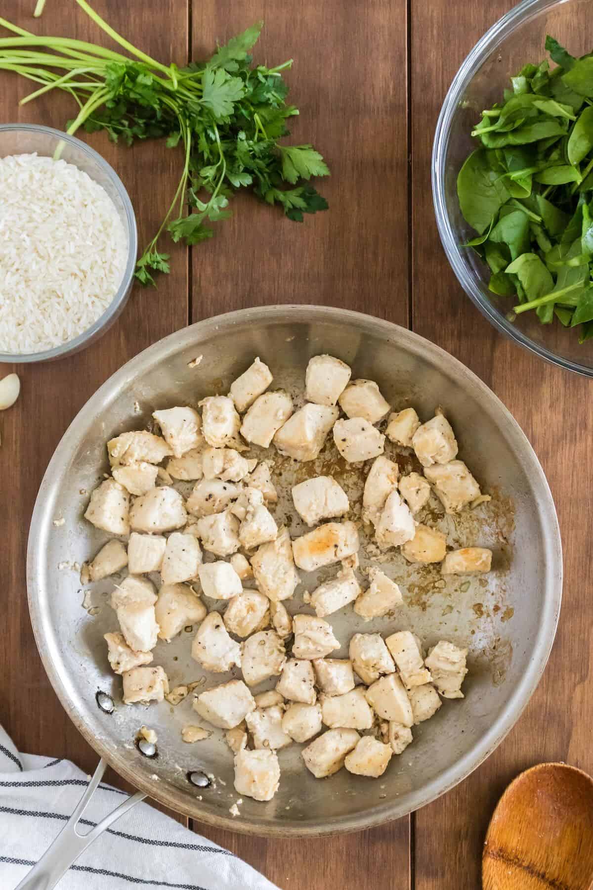 Pan-sear chicken cut into cubes in a skillet.