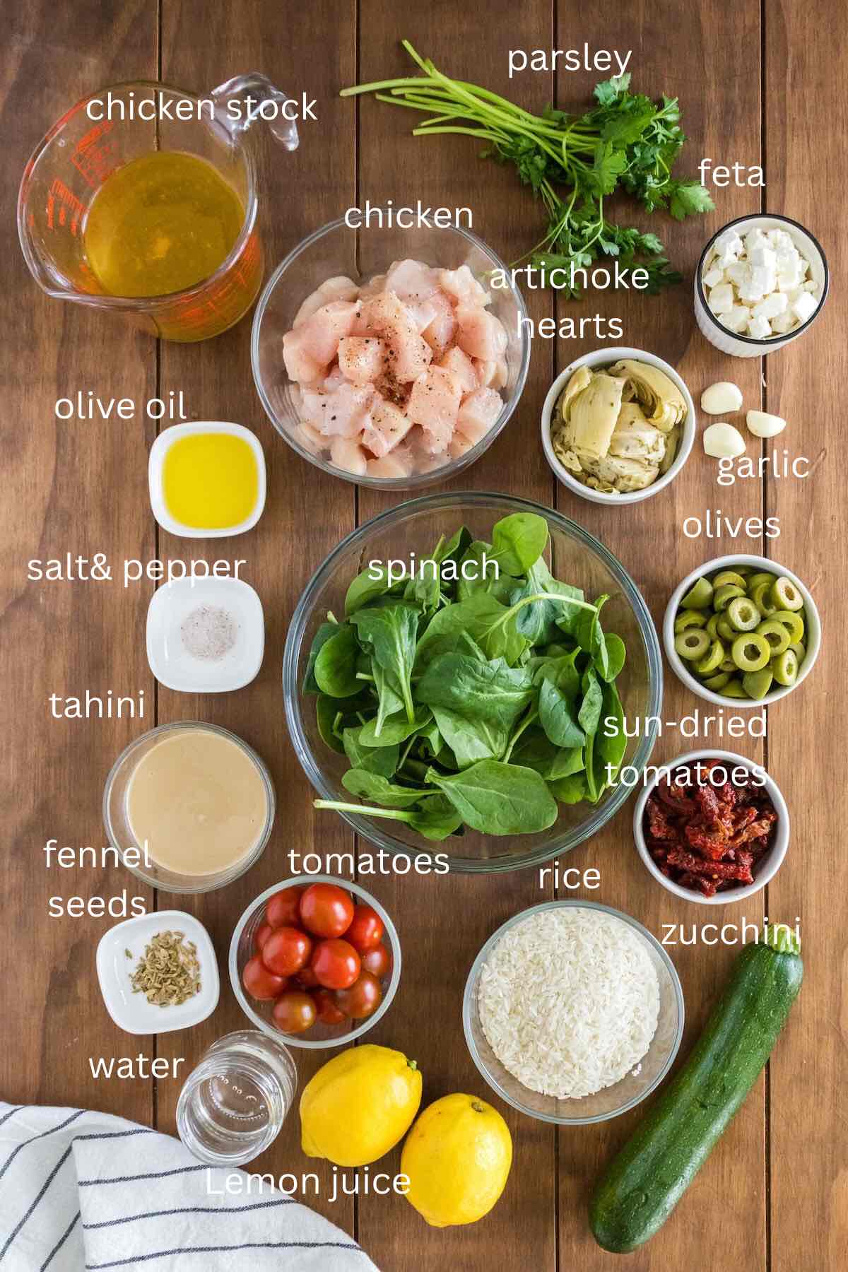 Ingredients for Mediterranean Chicken and Rice Casserole with zucchini, tomatoes, spinach, and fresh lemons. 