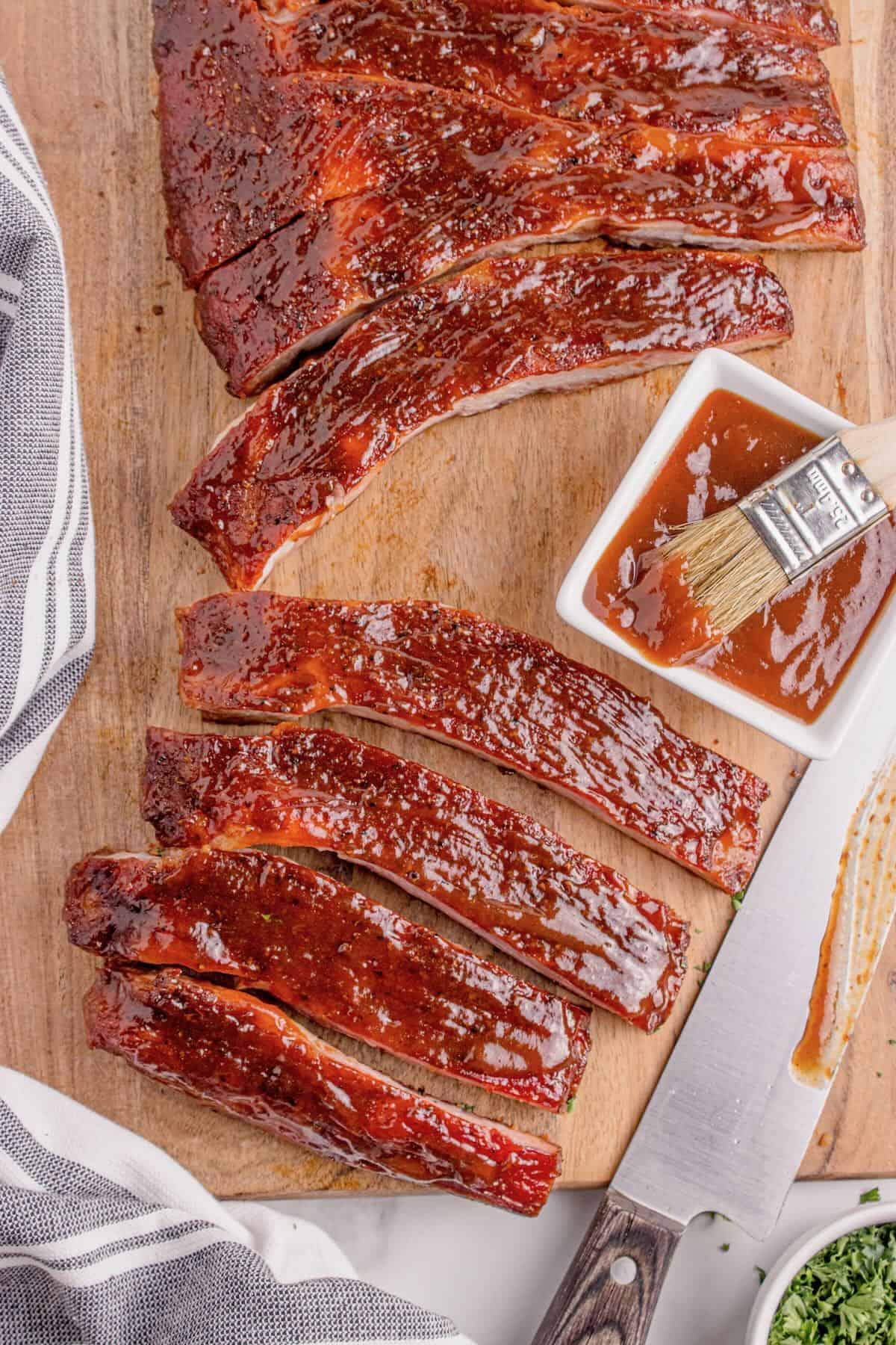 A rack of smoked spare ribs sliced on a cutting board.