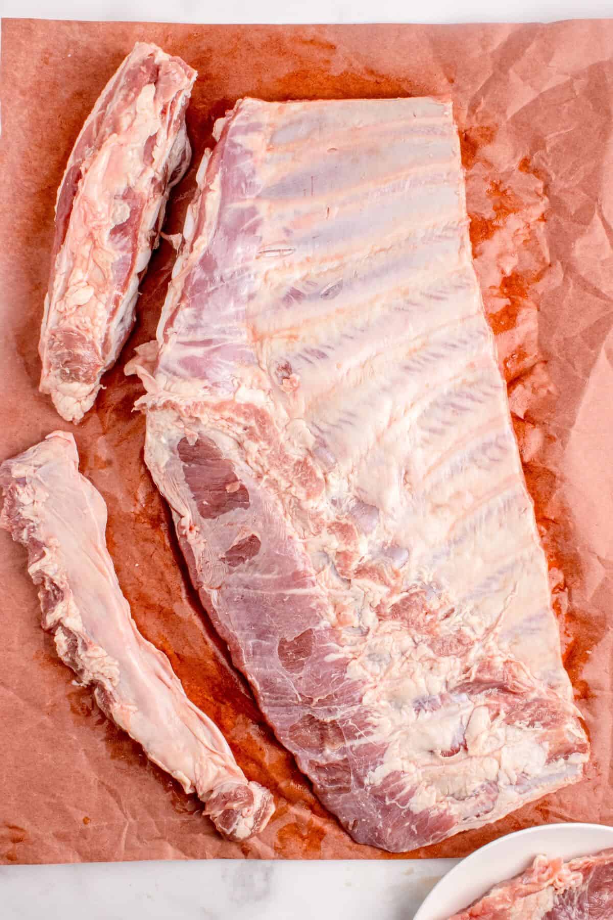 Trimming excess fat and bone from a rack of spare ribs. 