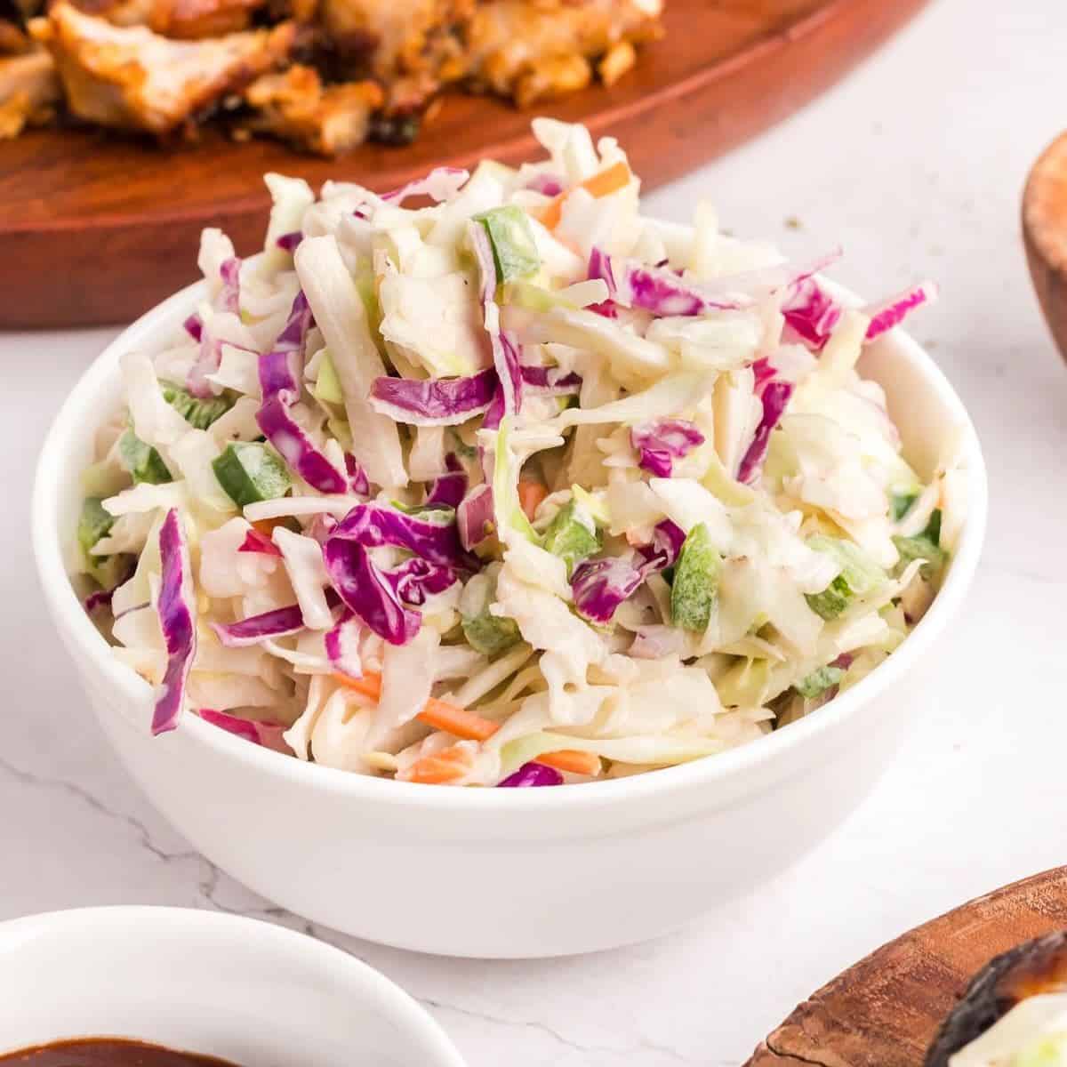 A large bowl of spicy coleslaw with shredded green and purple cabbage.  