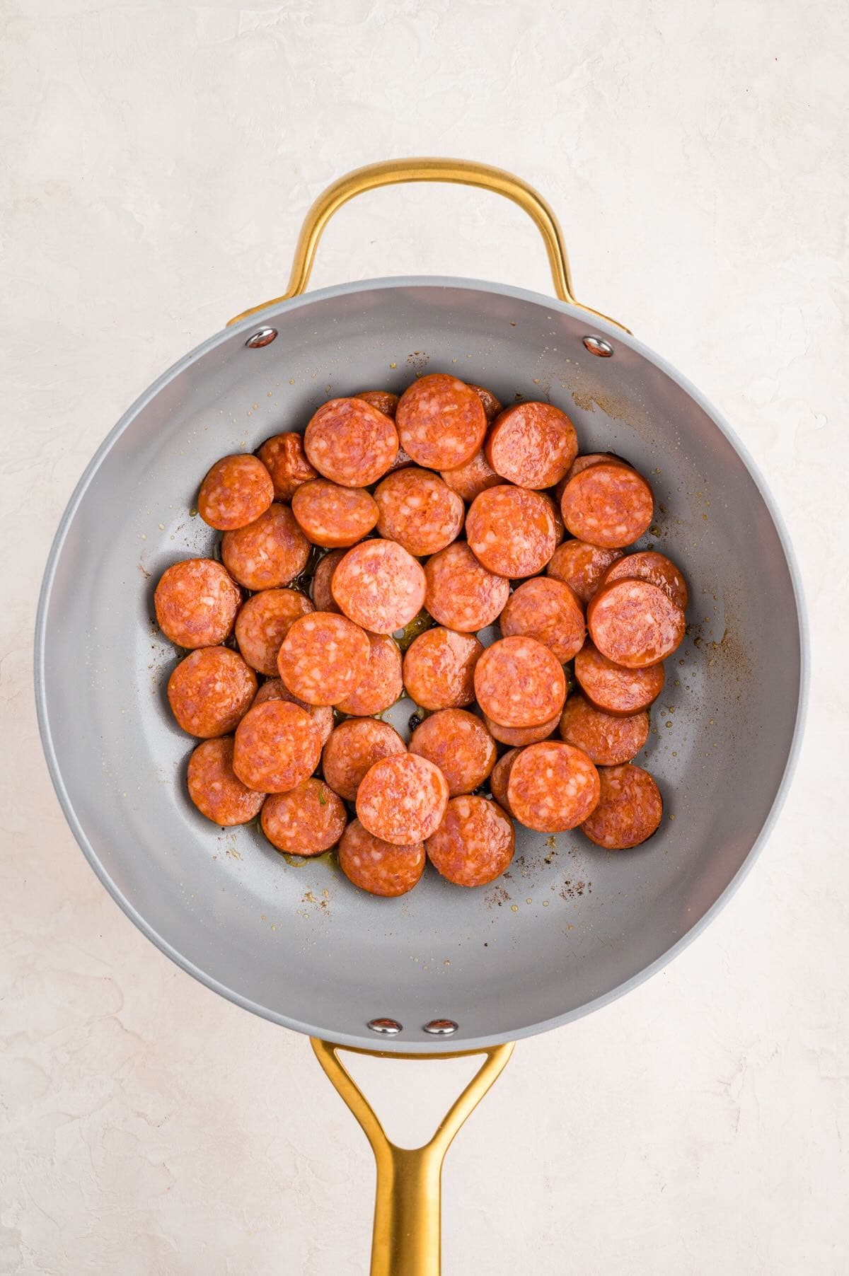 Browning sliced smoked sausage in a skillet. 