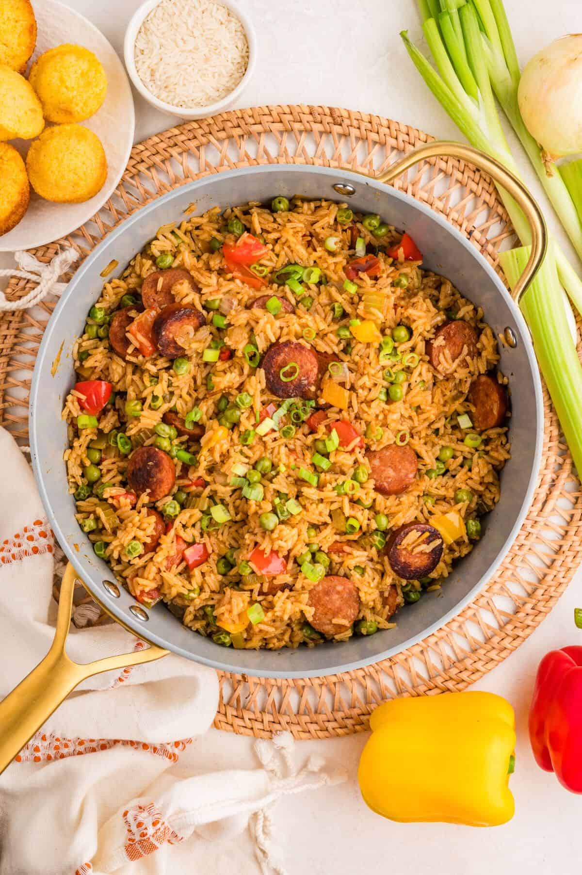 A large skillet full of Cajun sausage, rice, and vegetables. 