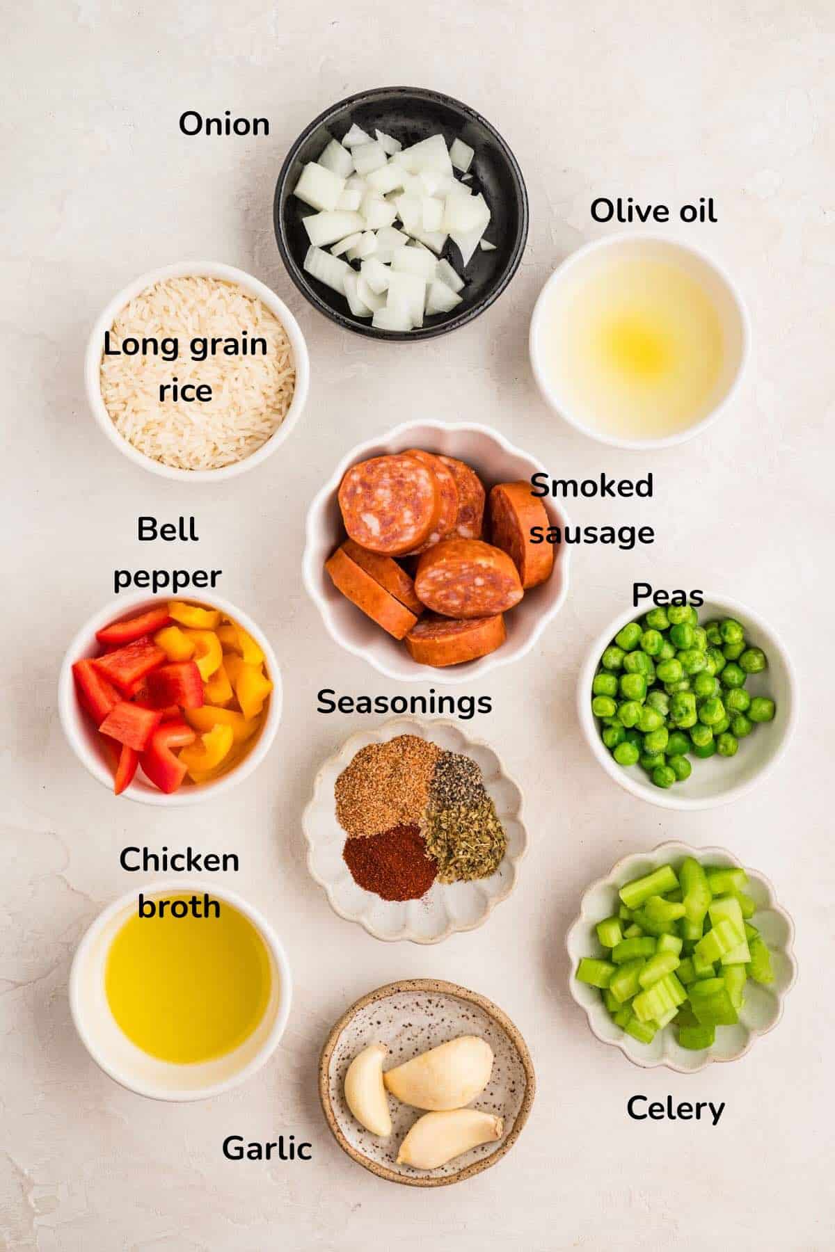 Ingredients for Cajun Sausage and Rice recipe includes, sliced sausage, chopped bell peppers and onions, chicken stock, rice, and seasonings. 