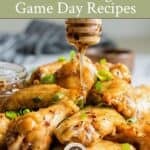 A plate full of chicken wings with honey drizzled over the top, plus text.