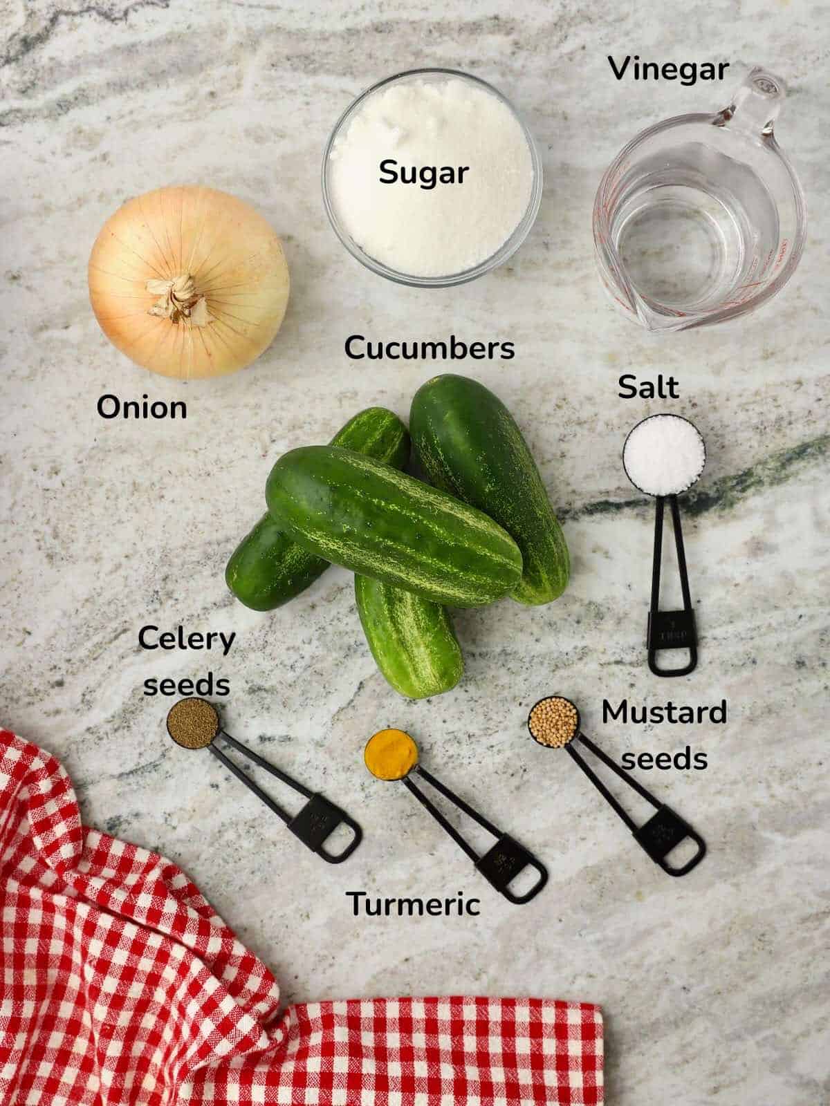 Ingredients for microwave bread and butter pickles including cucumbers, onions, vinegar, sugar, and seasonings. 