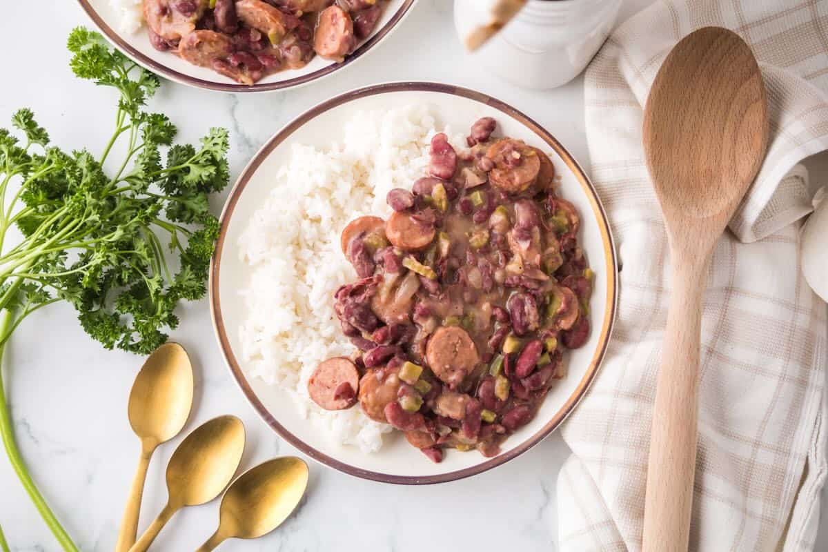 Cajun red beans and white rice on a serving plate with a gold rim.