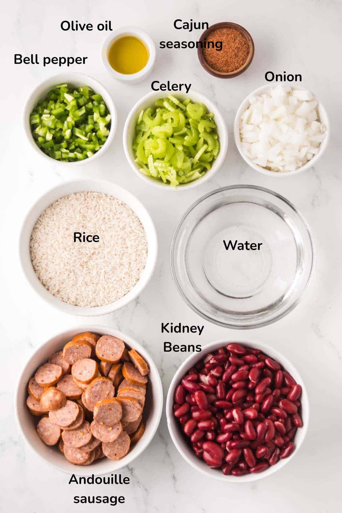Ingredients for Cajun red beans and rice include rice, kidney beans, andouille sausage, bell pepper, celery, onion, and Cajun seasoning.
