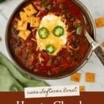 Pinterest pin with bowl of chuck roast chili topped with cheese, green onions, and sour cream, served with cornbread and Cheez-its on the side.