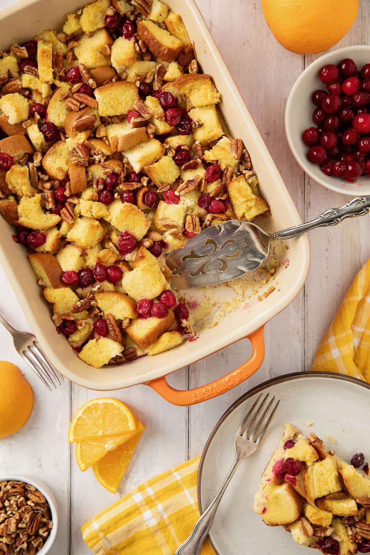 A casserole dish with baked brioche french toast with cranberries, and a plate full.