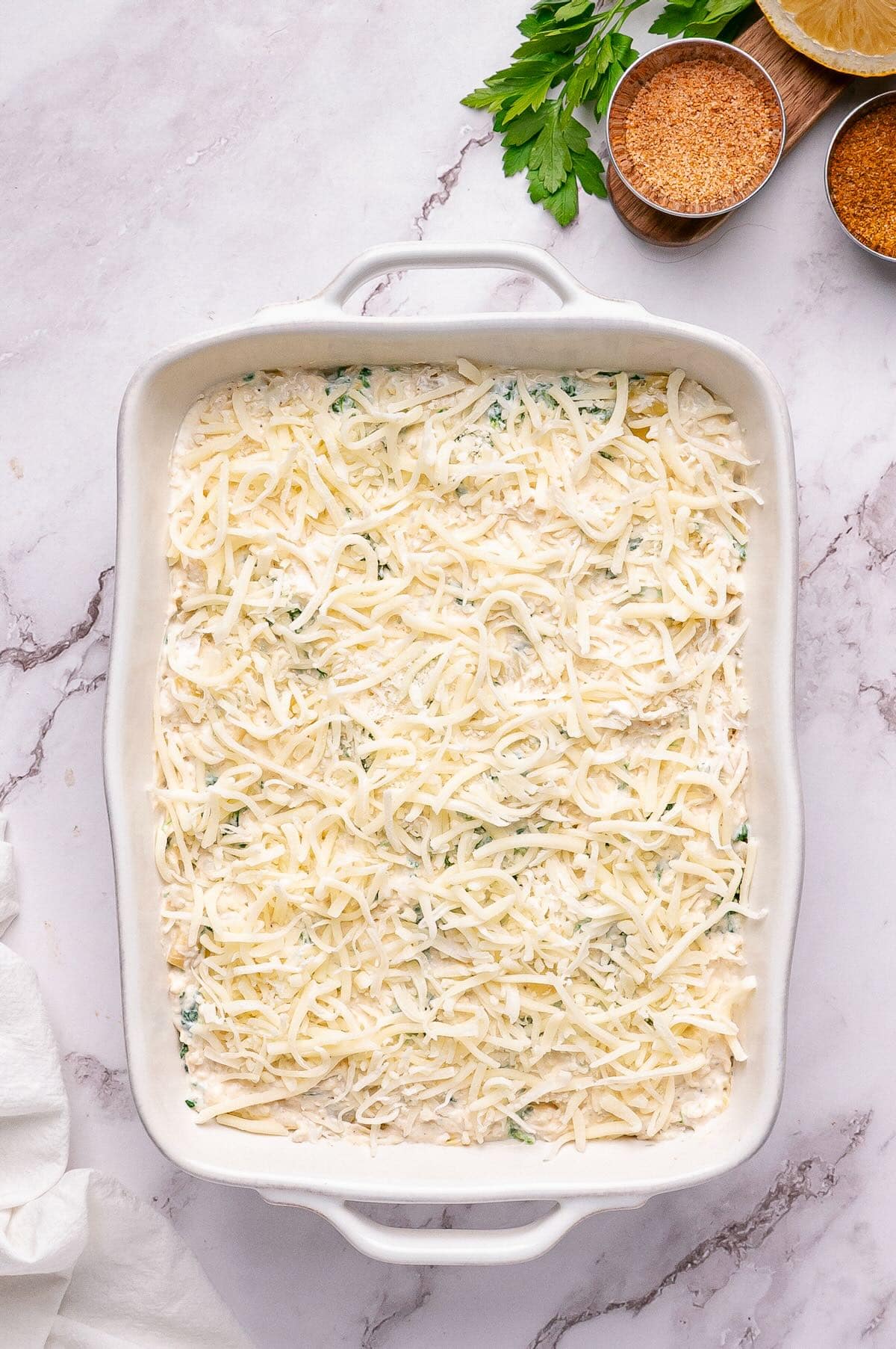 Mixture is placed in a rectangle baking dish and topped with shredded mozzarella cheese. 