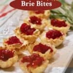A white serving platter with Cranberry Brie Bites garnished with sprigs of rosemary.