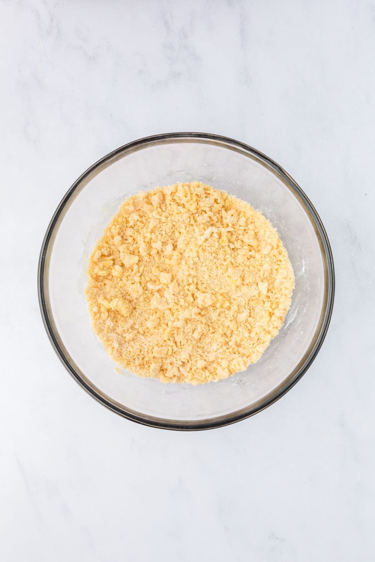 Topping ingredients for pecan pie dump cake in a bowl include cake mix, butter, and spices. 