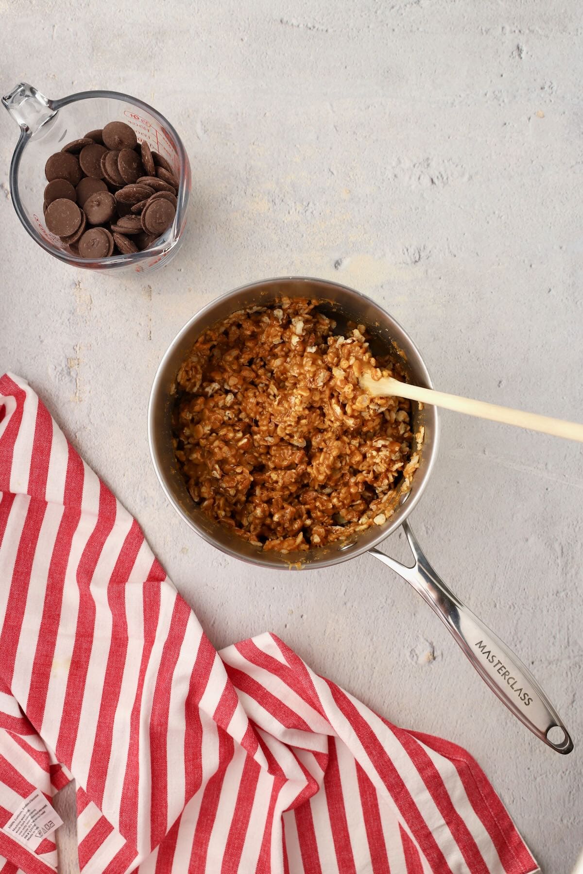Rice Krispies and pecans are added to melted caramel in a saucepan and combined. 