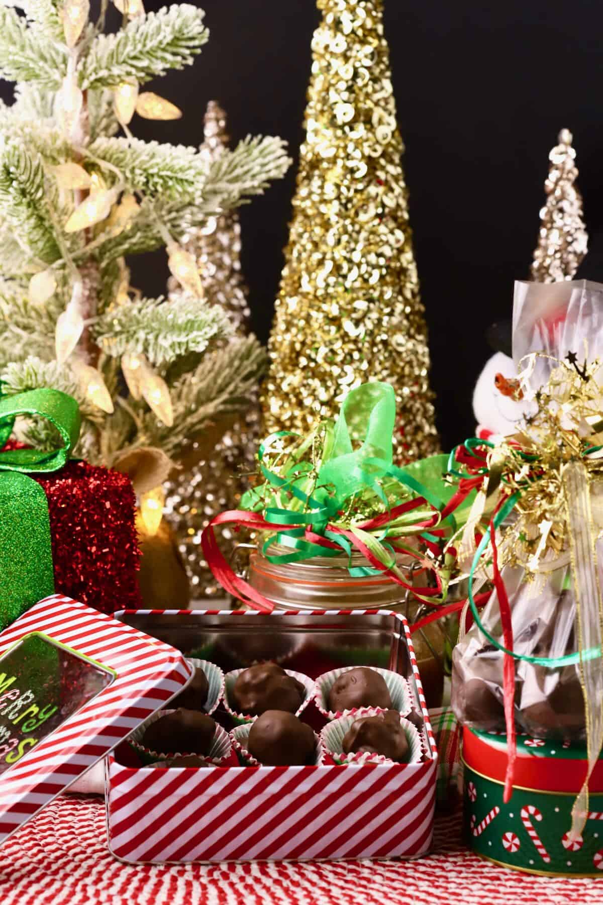A metal tin full of Chocolate Billionaire candy in front of Christmas decorations. 