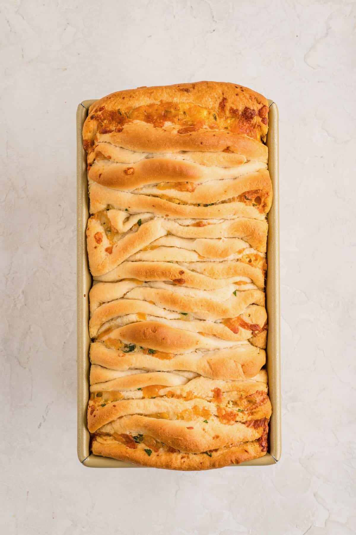 A loaf of baked garlic cheese pull-apart bread straight out of the oven.