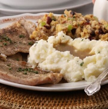Pan seared turkey cutlets served with cornbread dressing, and pan gravy over mashed potatoes.