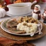 A plate full of pan seared turkey cutlets, pan gravy and cornbread dressing.