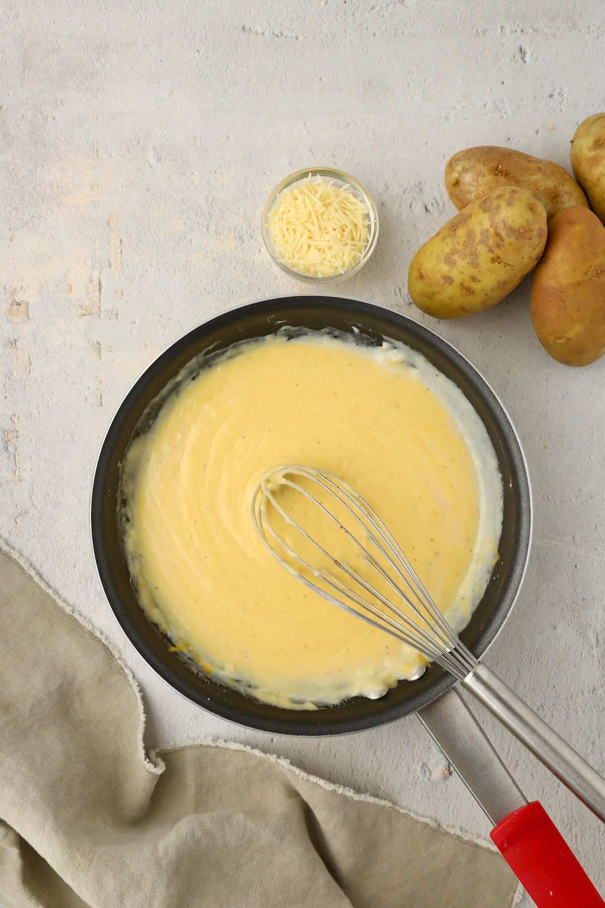 Cheese is added to the flour, butter, and seasonings to make a cheesy bechamel sauce.