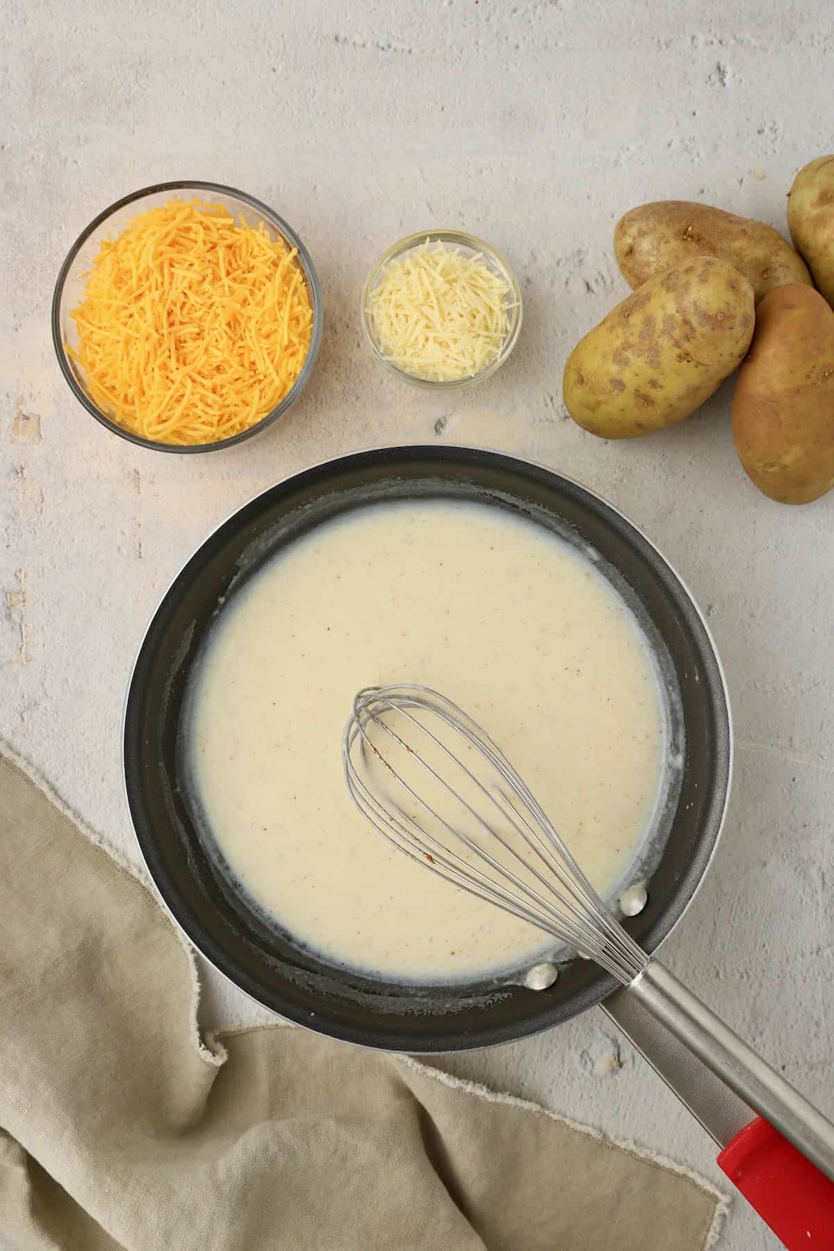 Milk is added to flour and butter in a skillet.