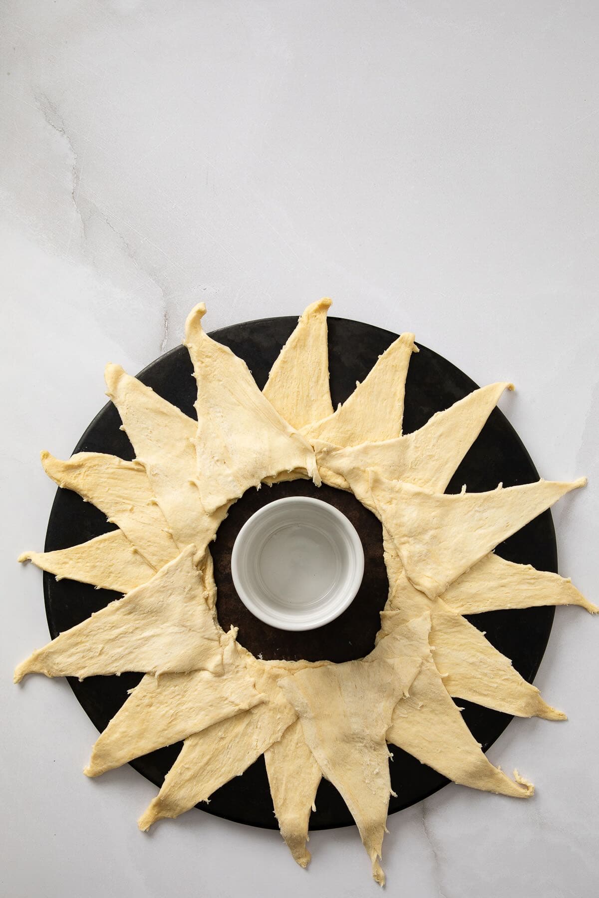 Crescent rolls are arranged in a circle with the points facing outward.